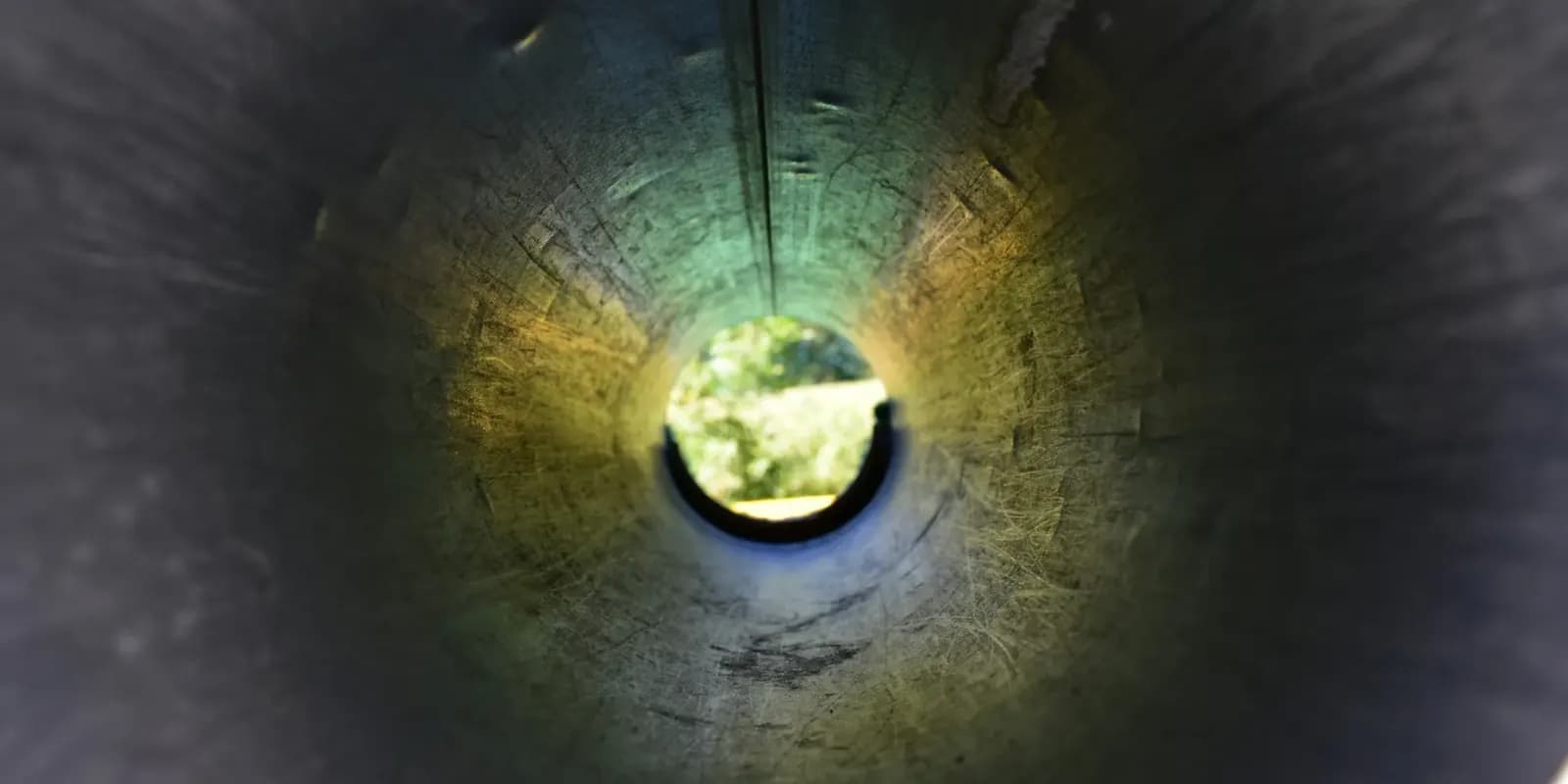 View along the inside of a pipe towards a circle of light at the far end