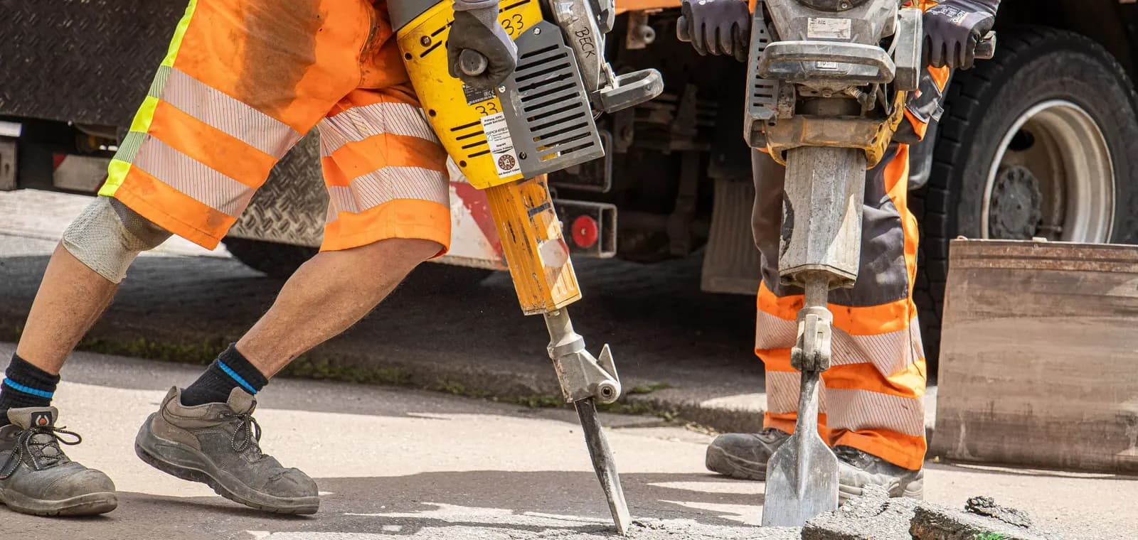 Drainage engineers in hi-vis breaking out around a manhole