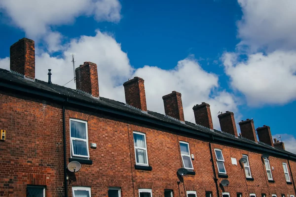 A row of red-brick terraced houses with chimneys