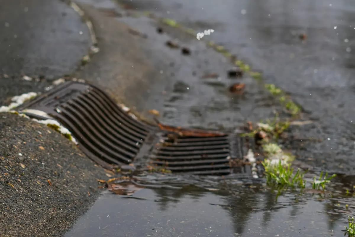 Surface water running along a kerb into a roadside drain