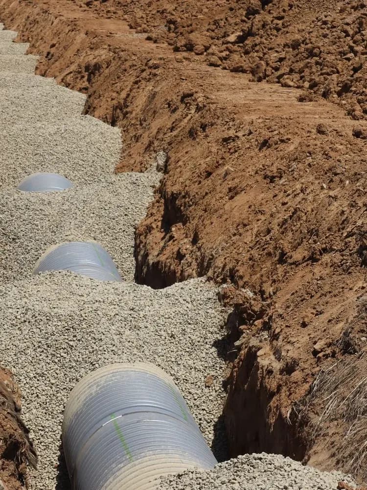 Excavated trench exposing a drainage pipe for repair