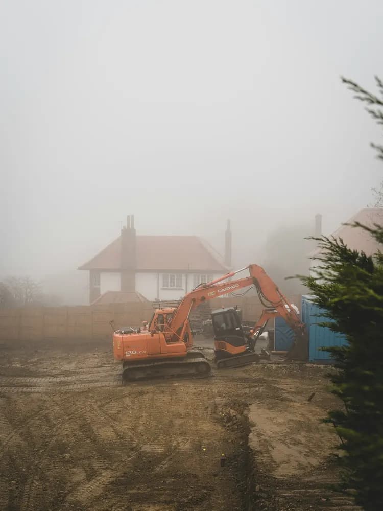Mini digger excavating a trench for new drainage